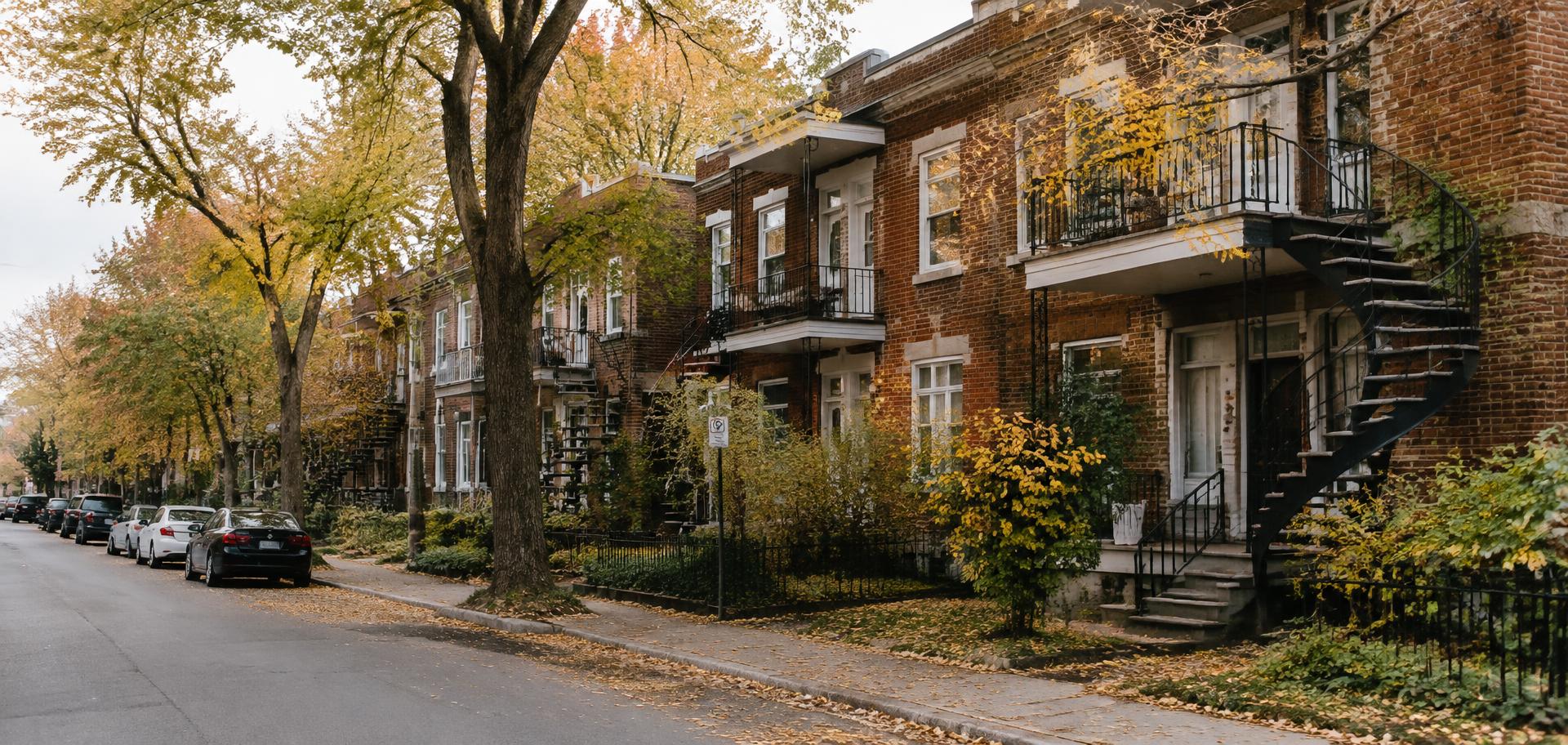 A tree-lined residential street in Notre-Dame-de-Grâce with brick duplexes and spiral staircases in autumn